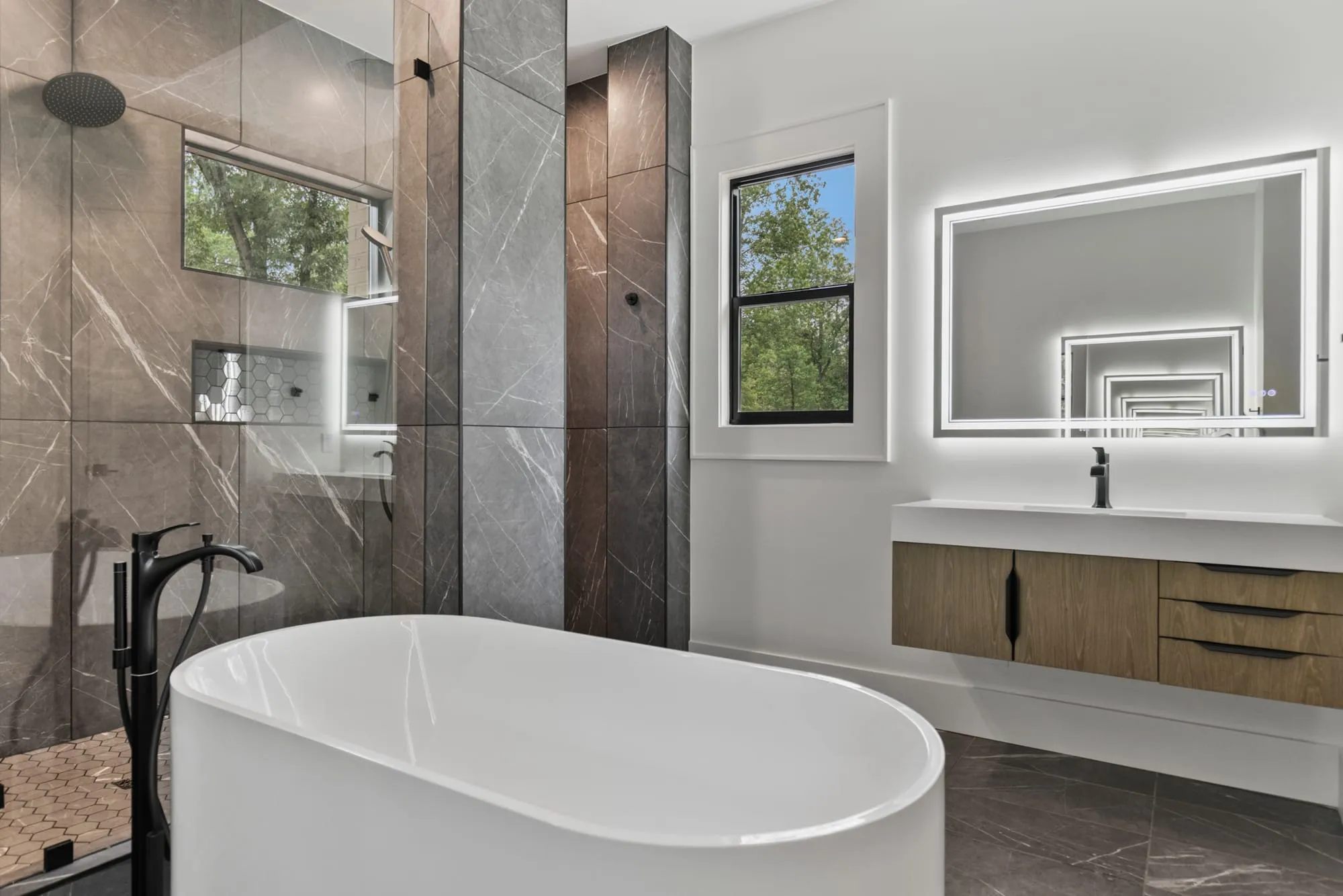 Primary bath with a freestanding tub and full-height stone slab walls