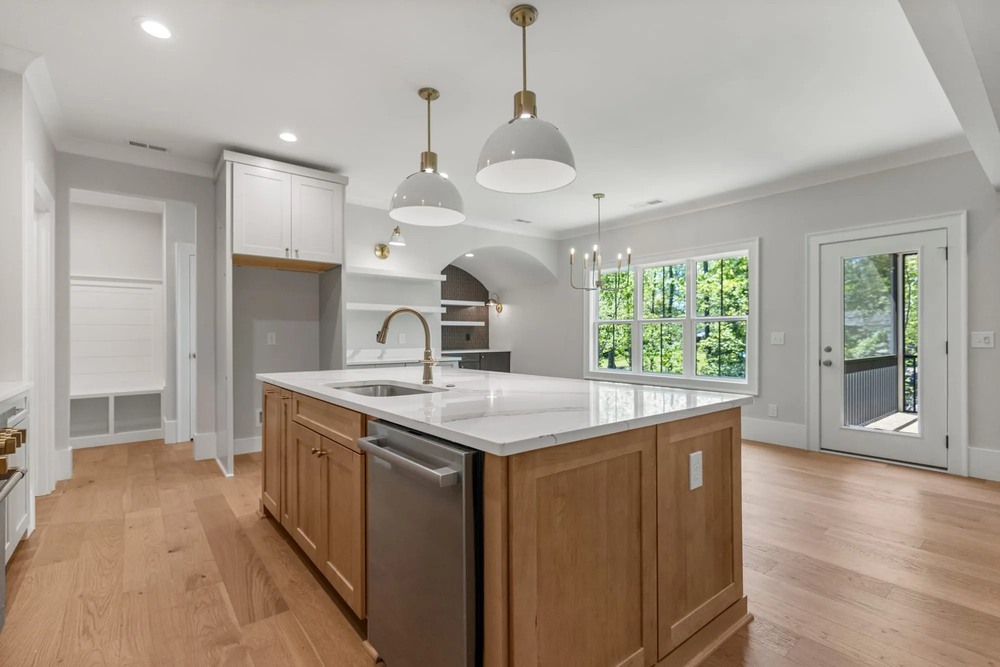 Trivium custom kitchen with a wood island, white cabinetry and a window onto the trees