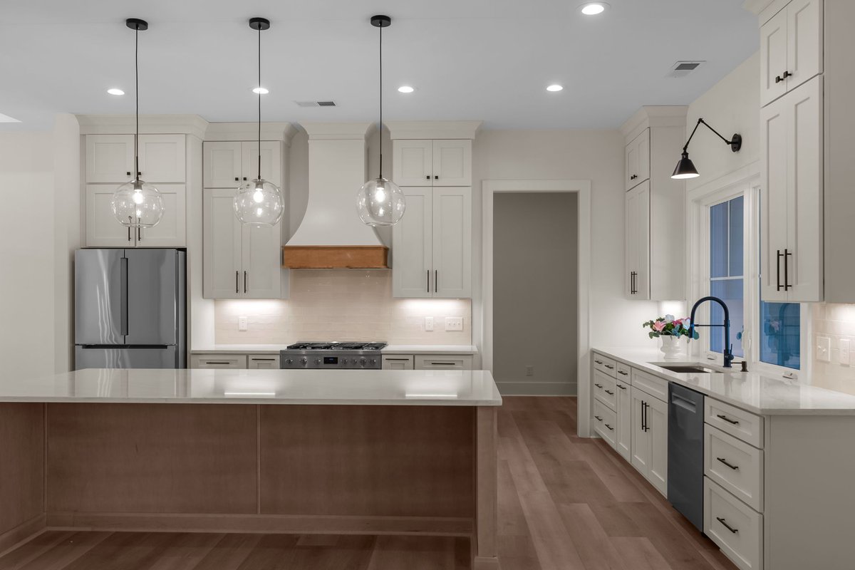 Custom kitchen interior with white cabinetry and a wood range hood